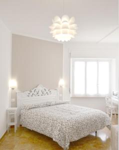 莱万托Villa Mori的白色卧室配有一张床和一个吊灯