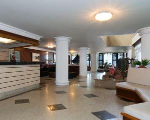 瓜拉派瑞Hotel da Lea的一间带柱子的客厅和一个带沙发的大堂