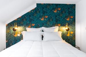 尼斯阿罗米酒店的一间卧室配有一张白色大床,铺有热带壁纸
