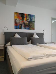 登肯多夫施图本-莫扎特酒店的一间卧室设有两张床,墙上挂着一幅画