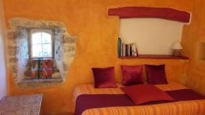 Limogne-en-QuercyLa Hulotte的一间卧室配有一张带红色枕头的床和一扇窗户