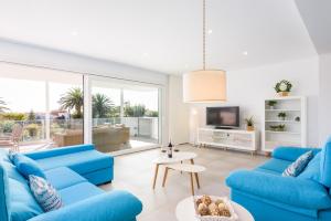 圣托马斯VILLA LUCIA B17的客厅配有蓝色的沙发和电视