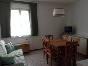 卡尔多纳佐Appartamento Guccio的客厅配有桌椅和电视。
