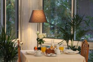雅典阿克琉斯酒店的一张桌子,上面有白色的桌布和一盏灯