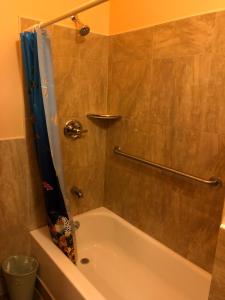 莫罗贝2172-2178主街公寓的浴室配有浴缸和淋浴,淋浴为蓝色的浴帘