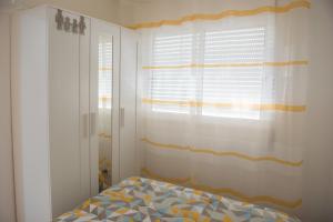 塞辛布拉Tropical house的一间卧室配有床和带窗帘的窗户