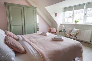 埃彭Hotel - Restaurant De 4 Jaargetijden的一间卧室配有一张带粉红色床单的大床