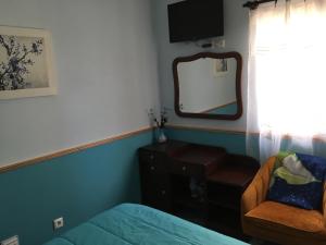 Praia do NorteAdelaide House的一间卧室配有一张床、镜子和椅子