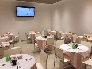 热那亚贝尔索吉奥诺酒店的一间带桌椅和电视的用餐室