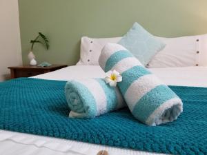 埃尔利海滩海湾背包客旅馆的床上的毛巾和鲜花