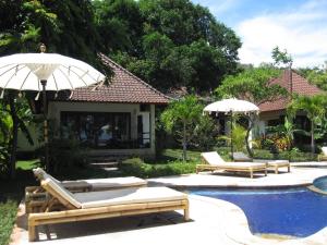 艾湄湾巴厘岛梦想之家酒店的一个带2把躺椅和遮阳伞的游泳池