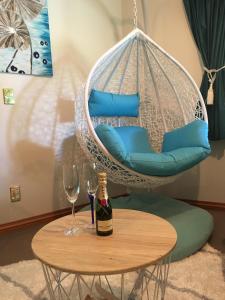 皇后镇Breakfast at Tiffanys的秋千椅,配有一瓶葡萄酒和两杯酒