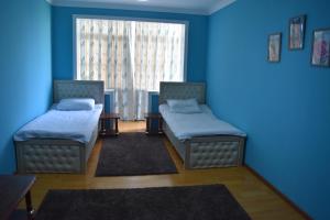 苦盏Golden Apartments的配有两张床铺的蓝色墙壁和窗户