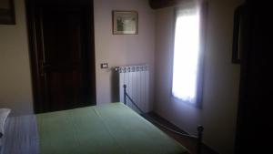 文蒂米利亚博伊罗坎达宾馆 的一间卧室设有一张绿色的床和一个窗户。