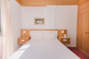 里斯本圣母蒙特蒂旅馆的一间卧室配有白色床和2个床头柜