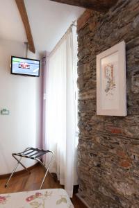 里奥马哲雷兰科拉酒店的一间卧室设有石墙和窗户。