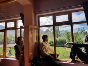 列城Lhachik Guest House的一群人坐在窗外的房间