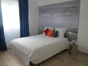 埃塔普勒奥帕尔海岸酒店的卧室配有带枕头的大型白色床