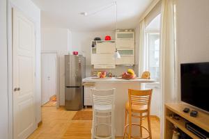 布德瓦Portun Apartment的厨房配有冰箱和带凳子的台面