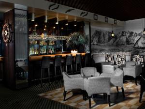 海法丹卡梅尔酒店的餐厅内的酒吧配有椅子和柜台