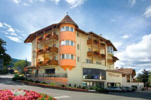 布列瑟农Hotel Millanderhof的一座大型橙色建筑,在街上设有阳台