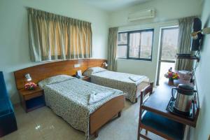 孟买YMCA International House的酒店客房设有两张床和窗户。