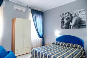 蒙塔尔托迪卡斯特罗Hotel Ospite Inatteso的一间卧室配有一张床,一张两人的照片