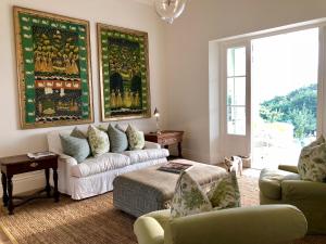 弗朗斯胡克La Cotte Orchard Cottages的带沙发和椅子的客厅以及窗户。