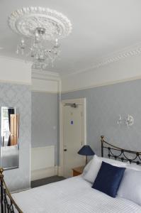 兰迪德诺Audley Guest House的一间卧室配有一张床和一个吊灯
