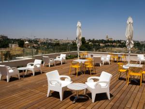 耶路撒冷耶路撒冷丹精品酒店的屋顶上带桌椅的甲板