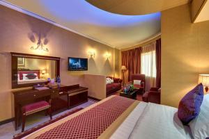迪拜德拉康福特茵酒店的配有一张床和一张书桌的酒店客房