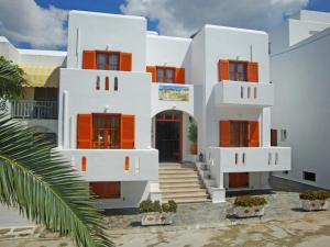 帕罗奇亚瓦西莉基客房酒店的白色的房子,有橙色百叶窗和棕榈树