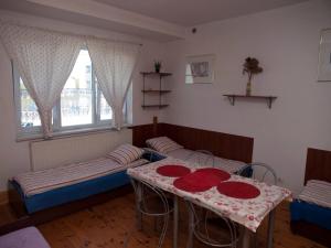 拉辛Pokoje Gościnne "Amelia"的一间设有两张床和一张桌子的房间