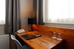 代尔夫宰尔昂德新格尔酒店的一张带电话的木桌和一本书