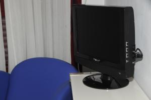圣塞巴斯蒂安德洛斯雷耶斯塞拉利昂旅馆的一张桌子上坐着一台电脑显示器,上面有蓝色的椅子