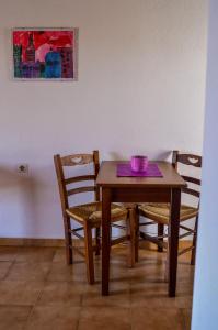 斯科拉洛曼萨公寓的一张带椅子的木桌和一碗紫色的碗