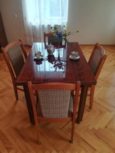 泰拉维Guesthouse "KISTAURI"的一张带椅子的木桌和木地板