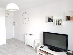 阿格特Apartamento Playa Agaete的客厅配有电视和墙上的时钟