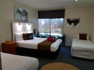 海伊Bidgee Motor Inn的酒店客房设有两张床和窗户。