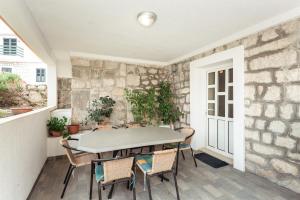 布拉采Apartmani Sršen的一个带桌椅和石墙的庭院