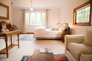 波高尔宾马车葡萄园精品酒店 的一间卧室配有一张床、一张沙发和一张桌子