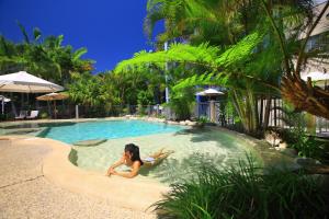 卡伦德拉海边的波多贝罗酒店的躺在度假村游泳池中的女人