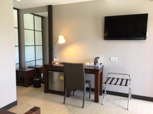 科内Hotel Colibri的一间房间,配有一张桌子和一台墙上的电视