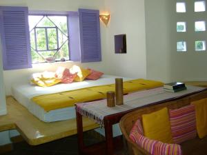 科苏梅尔阿马兰托住宿加早餐酒店的一间卧室配有一张带窗户和桌子的床