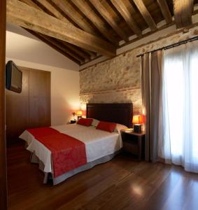 Los Santos de la Humosa罗马教皇酒店的一间卧室配有一张带红色毯子的大床