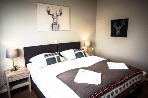 格拉茨附近卡尔斯多夫Cafe-Restaurant LEO的卧室配有两张床,墙上挂着鹿的照片