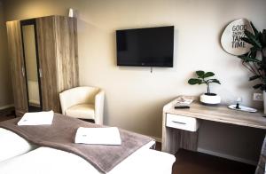 格拉茨附近卡尔斯多夫Cafe-Restaurant LEO的客房设有两张床和一台墙上的电视。