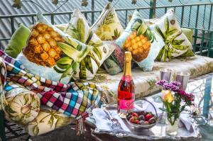 约翰内斯堡伊丽莎白庄园旅馆的一张带枕头的沙发以及一张带一瓶葡萄酒的桌子