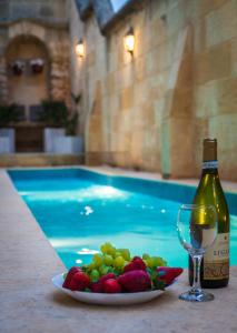 加拉Id Dar Ta Censu的游泳池旁的果盘和一瓶葡萄酒
