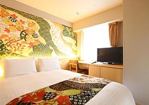 金泽金泽站前永安国际酒店 的一间酒店客房,配有一张床和一台电视